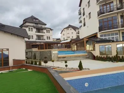 a large building with a pool in the middle of a yard at Milmari Premijer 30 Kopaonik in Kopaonik