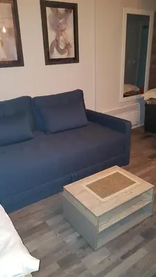 a blue couch in a living room with a table at Milmari Premijer 30 Kopaonik in Kopaonik
