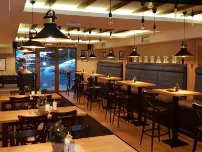 a restaurant with wooden tables and chairs and lights at Milmari Premijer 30 Kopaonik in Kopaonik