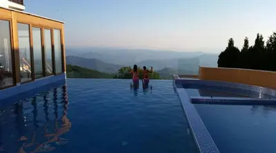 two people standing on the edge of a swimming pool at Milmari Premijer 30 Kopaonik in Kopaonik