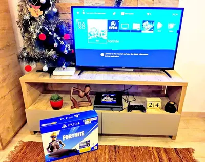 a tv on a stand with a box and a christmas tree at Kopaonik Milmari Spa and Wellness Wooden Horn S21 in Kopaonik