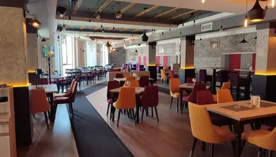 a restaurant with tables and chairs in a room at Kopaonik Milmari Spa and Wellness Wooden Horn S21 in Kopaonik