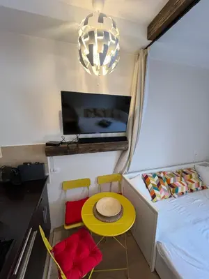 a small room with a bed and a yellow table and chairs at Apartman Brvenik 103, Konaci, Kopaonik in Kopaonik