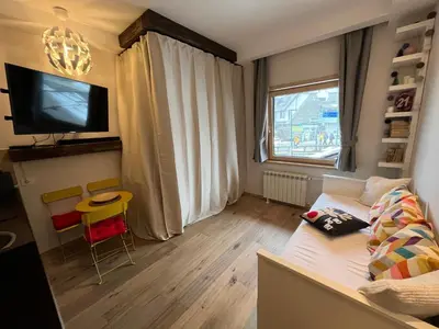 a small living room with a couch and a tv at Apartman Brvenik 103, Konaci, Kopaonik in Kopaonik