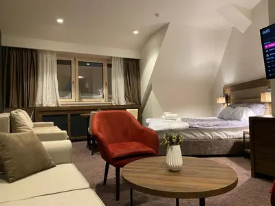 a hotel room with a bed and a couch and a table at Teddy Apartman Kula Konaci in Kopaonik