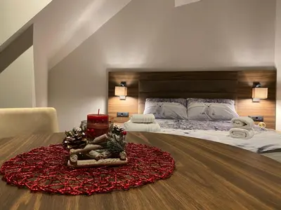 a bedroom with a bed with a red rug on a table at Teddy Apartman Kula Konaci in Kopaonik
