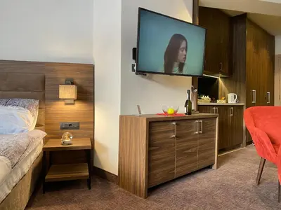 a hotel room with a bed and a flat screen tv at Teddy Apartman Kula Konaci in Kopaonik