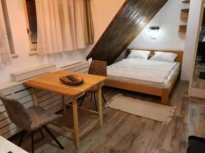 a bedroom with a bed and a table and a table and chairs at VT apartman-KOZNIK in Kopaonik