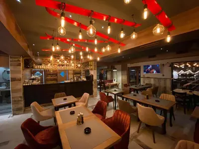a restaurant with tables and chairs and a bar at VT apartman-KOZNIK in Kopaonik