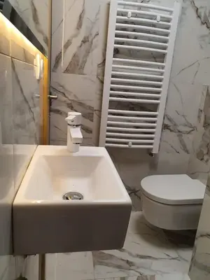 a white bathroom with a sink and a toilet at VT apartman-KOZNIK in Kopaonik