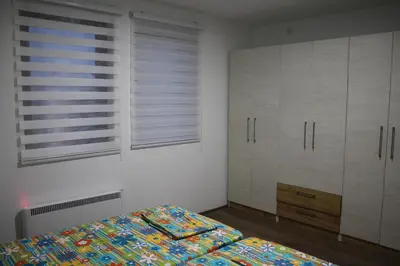 a bedroom with a bed and white cabinets and a window at Sunčani breg in Kopaonik