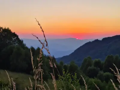 a sunset in the mountains with the sun setting at Starloft Kopaonik in Kopaonik