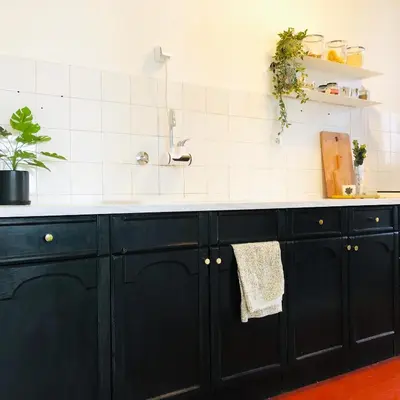 a kitchen with black cabinets and a sink at Alva Apartment in Niš