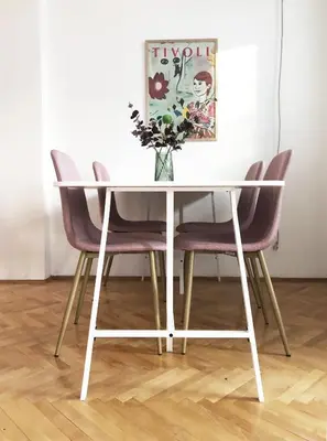 a dining room table with chairs and a vase of flowers at Alva Apartment in Niš