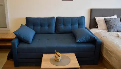 a blue couch in a living room with a table at DA-MA Milmari in Kopaonik