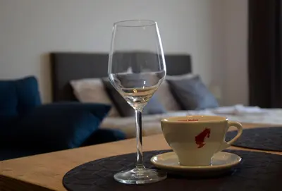 a glass of wine and a cup on a table at DA-MA Milmari in Kopaonik