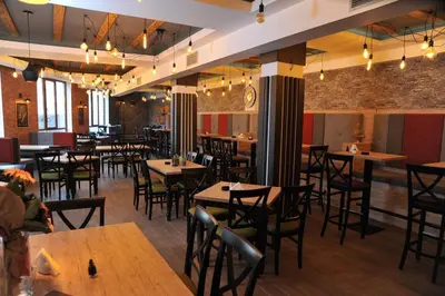 a restaurant with tables and chairs and a clock on the wall at DA-MA Milmari in Kopaonik
