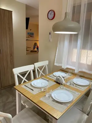 a dining room table with white plates and a clock at Apartmani Jelica FREE PARKING in Vranje