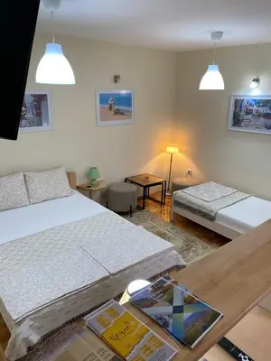 a hotel room with two beds and a table with a table at Apartmani Jelica FREE PARKING in Vranje
