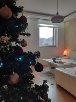 a christmas tree in a living room with a couch at Apartman Teodora in Kopaonik