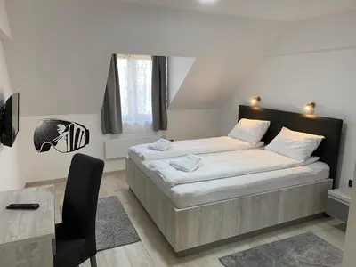 a small bedroom with a bed and a desk at FamilyKop Apartments Milmari in Kopaonik