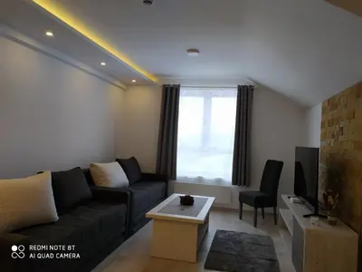a living room with a couch and a table at FamilyKop Apartments Milmari in Kopaonik