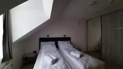 a bed with white sheets and towels on it at FamilyKop Apartments Milmari in Kopaonik