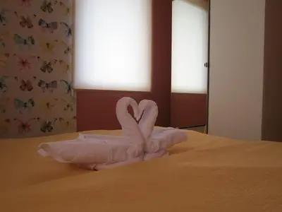 two swans made out of towels on a bed at Apartman Žuta dunja - Sunčani breg in Kopaonik