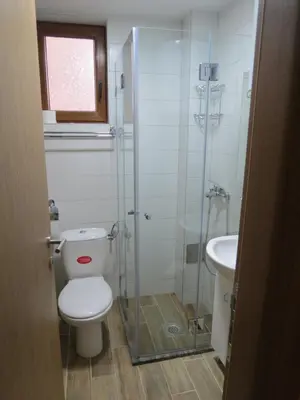 a bathroom with a shower and a toilet and a sink at Apartman Žuta dunja - Sunčani breg in Kopaonik