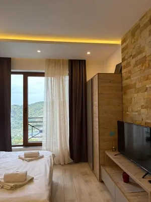 a bedroom with a bed and a large window at Milmari apartman SAN-28 in Kopaonik