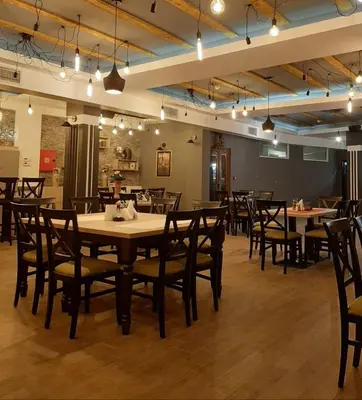 a dining room with tables and chairs and lights at Milmari apartman SAN-28 in Kopaonik