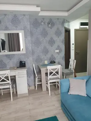a living room with a blue couch and a table at Milmari apartman SAN-28 in Kopaonik