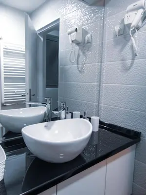 a bathroom with a white sink and a mirror at Stan na dan - apartman Djordjevic in Vranje