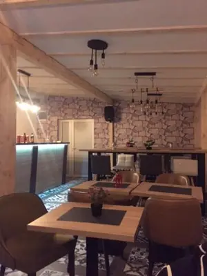 a dining room with tables and chairs and a stone wall at Sunčani Breg apartman 10 in Kopaonik