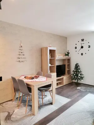 a dining room with a table and chairs and a christmas tree at Sunčani Breg apartman 10 in Kopaonik