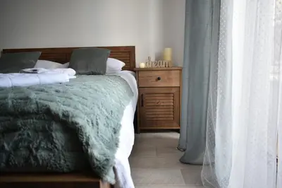 a bedroom with a bed with a green blanket at S 68, Milmari Resort in Kopaonik