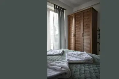 a bedroom with towels on a bed with a window at S 68, Milmari Resort in Kopaonik
