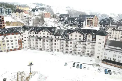 a city in the snow with buildings and cars at S 68, Milmari Resort in Kopaonik