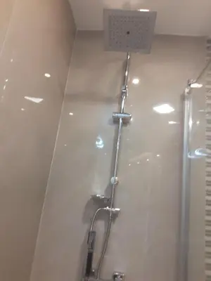 a white bathroom with a shower and a sink at Apartman Markos in Vrnjačka Banja