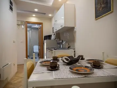a kitchen with a table with dishes on it at Apartman Markos in Vrnjačka Banja