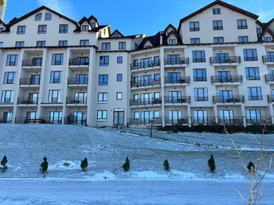 a group of people standing in the snow in front of a building at Apartment Mali Princ S18 Milmari resort in Kopaonik