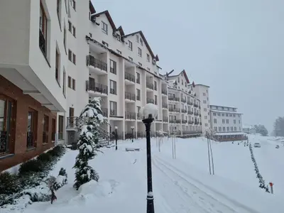 a snow covered street in front of a building at Apartment Mali Princ S18 Milmari resort in Kopaonik