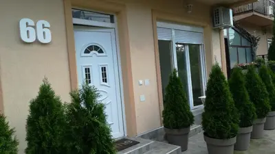 a front door of a house with potted trees in front at M4U Apartments in Niš