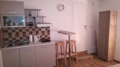 a kitchen with a sink and a counter with stools at M4U Apartments in Niš