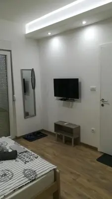 a living room with a flat screen tv on the wall at M4U Apartments in Niš