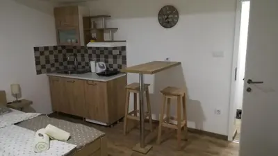 a kitchen with a counter and a sink and a table at M4U Apartments in Niš
