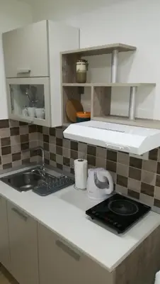 a white kitchen with a sink and a stove at M4U Apartments in Niš