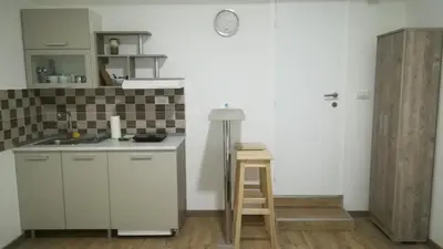 a kitchen with a counter and a sink and a stool at M4U Apartments in Niš