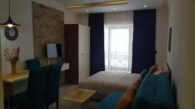 a bedroom with a blue couch and a bed and a window at Andre P05 Milmari in Kopaonik