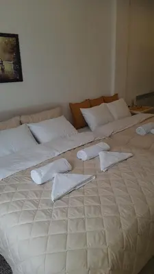 a large white bed with three pillows on it at Andre P05 Milmari in Kopaonik
